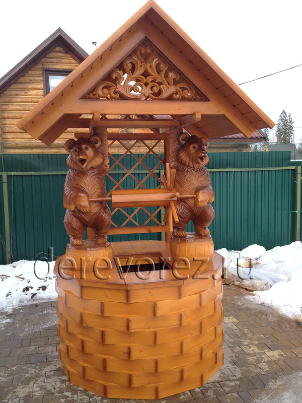 Домик на колодец украшен скульптурой медведей